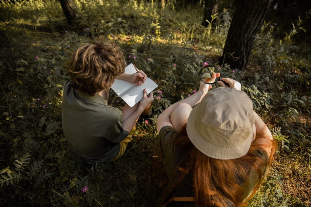 Home 25 A boy and a girl exploring the forest and taking notes.
