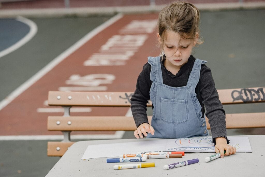 A child drawing outside at Schola Vera.