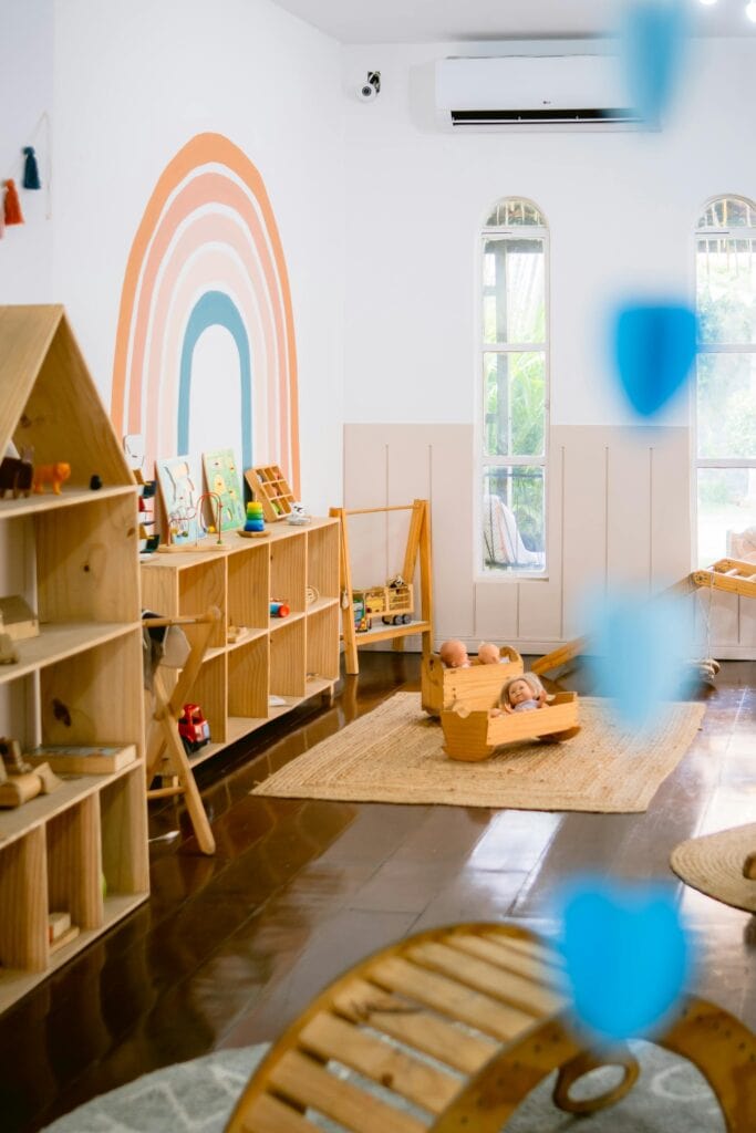 A playgroup room at Schola Vera full of wooden toys and bright colours.