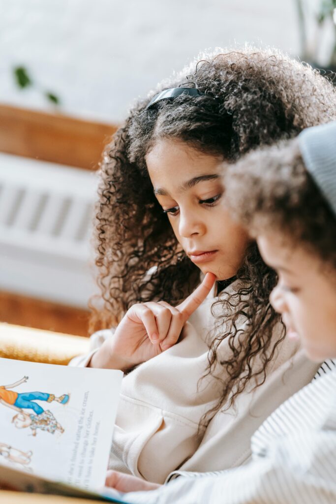 Two girls reading a book in the classroom.