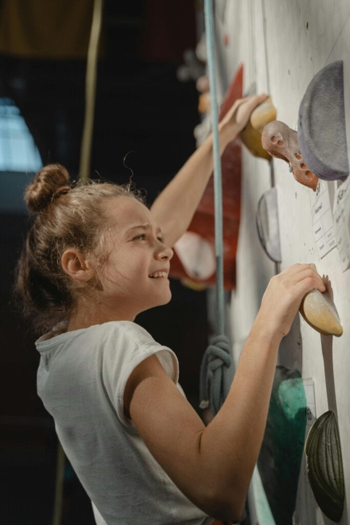 A girl climbing in a gym.