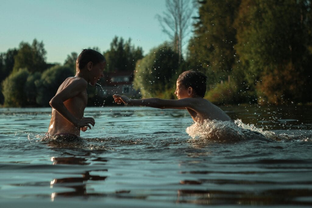Your Child's Natural Way Of Learning (It's Not What Traditional Schools Do) 6 Two Boys playing in the water being happy and engaged