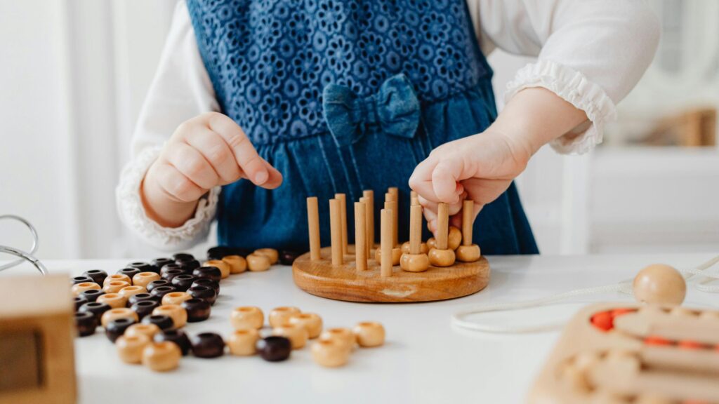 Montessori, Waldorf, or Something Different? A Parent's Guide to Educational Choices 2 A child playing with wooden toys on a table in a Montessori environment.