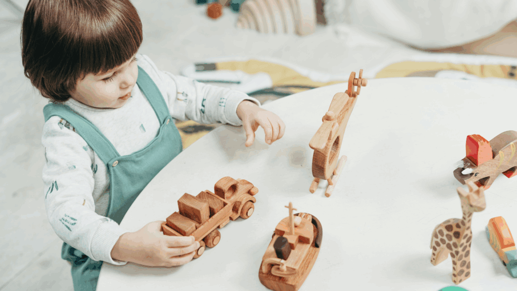 Why Your Preschool Choice Matters More Than Your University Choice 3 A toddler playing with wooden toys on a table.